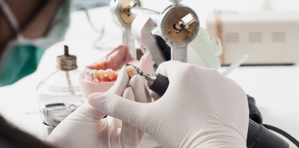 Dental lab technician working with drill
