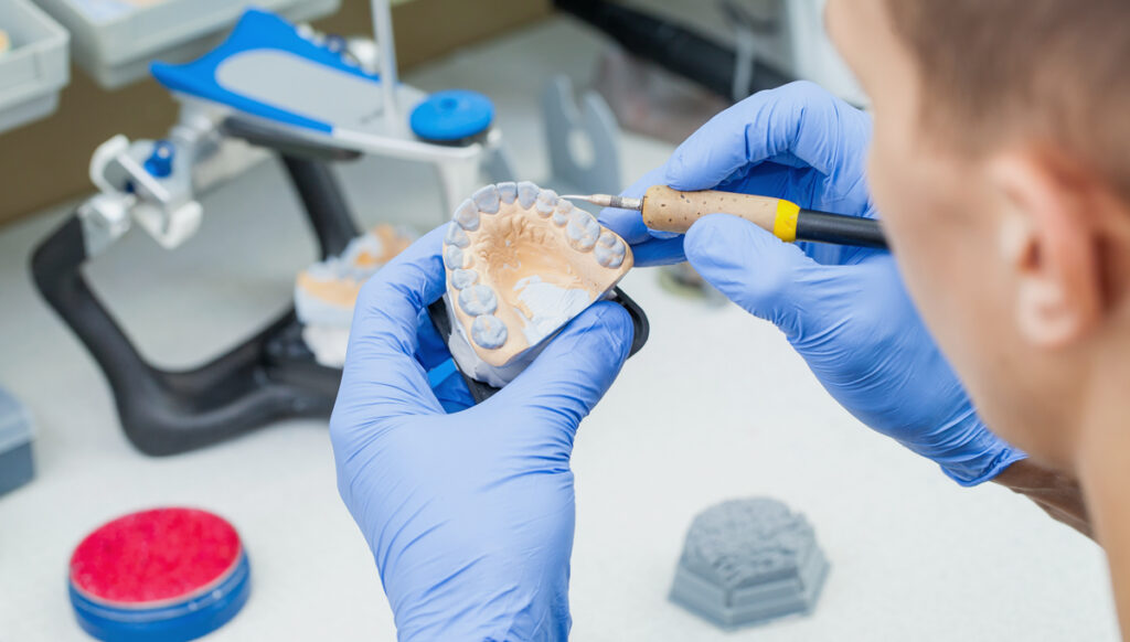 dental lab worker with mould detailing for turnaround times in large dental labs