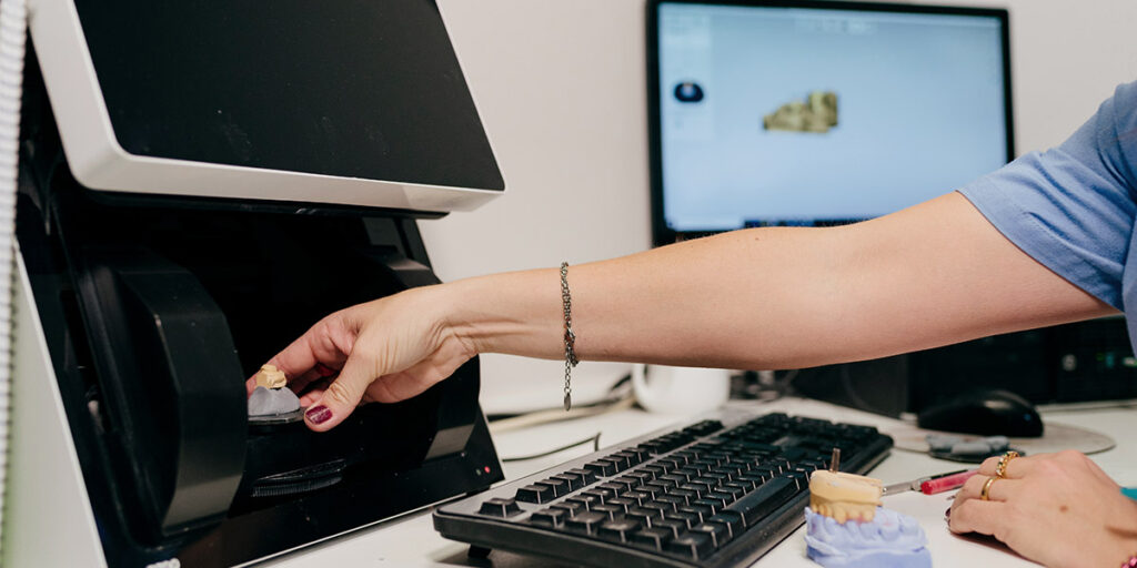 Hand grabbing dental lab part from STL files